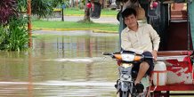 Mand på moto i vand i Cambodja